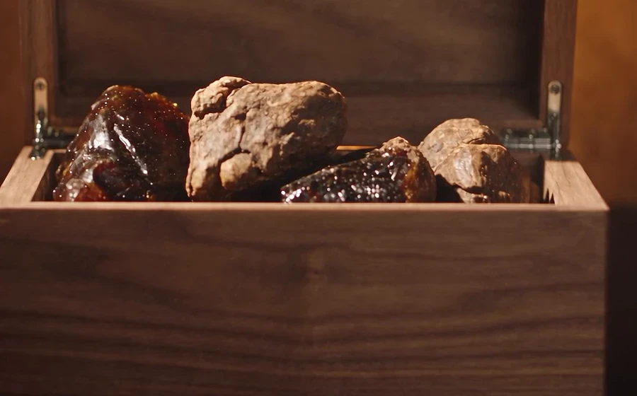 Raw lumps of amber resin and frankincense in an open walnut box