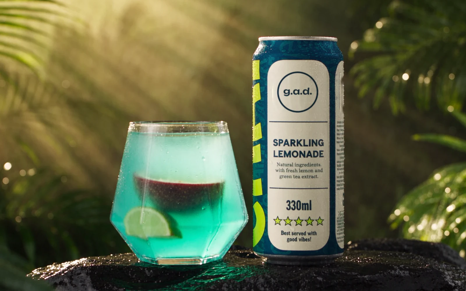 A faceted glass of lemonade with a lime wedge next to the g.a.d. can on wet stone