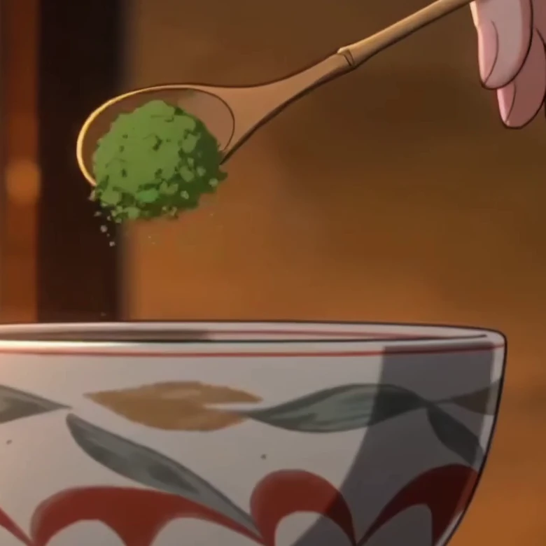 A bamboo scoop lifting matcha over a painted bowl