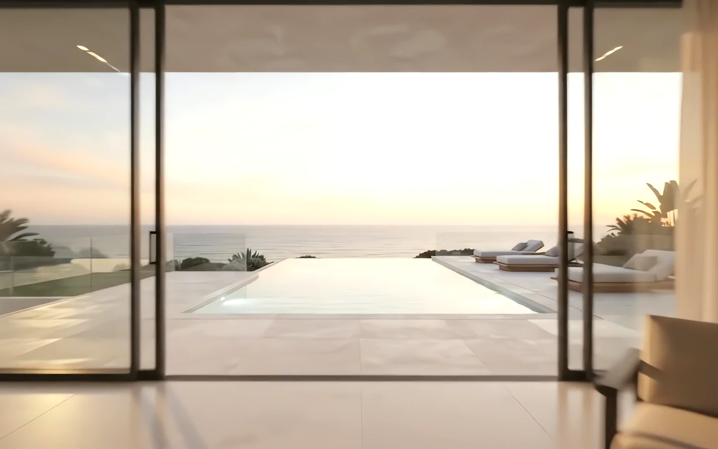 Glass doors open from the living room onto the pool terrace and the sea